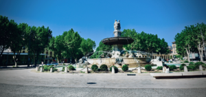 La Rotonde fountain in Aix-en-Provence with its iconic statues, flowing water, and lively city atmosphere