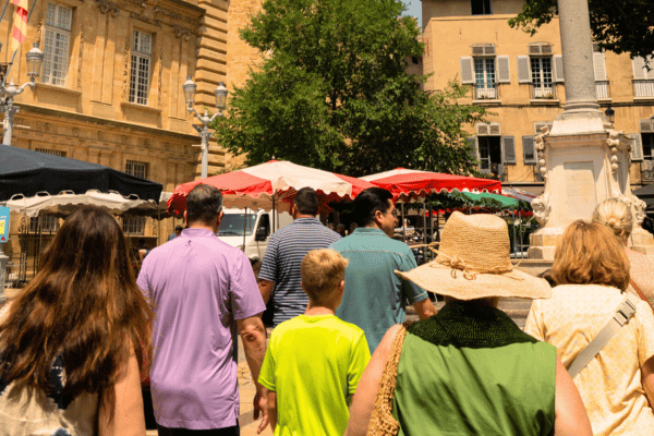 Local tour guide leading travelers through historic Place des Prêcheurs on Aix-en-Provence walking tour